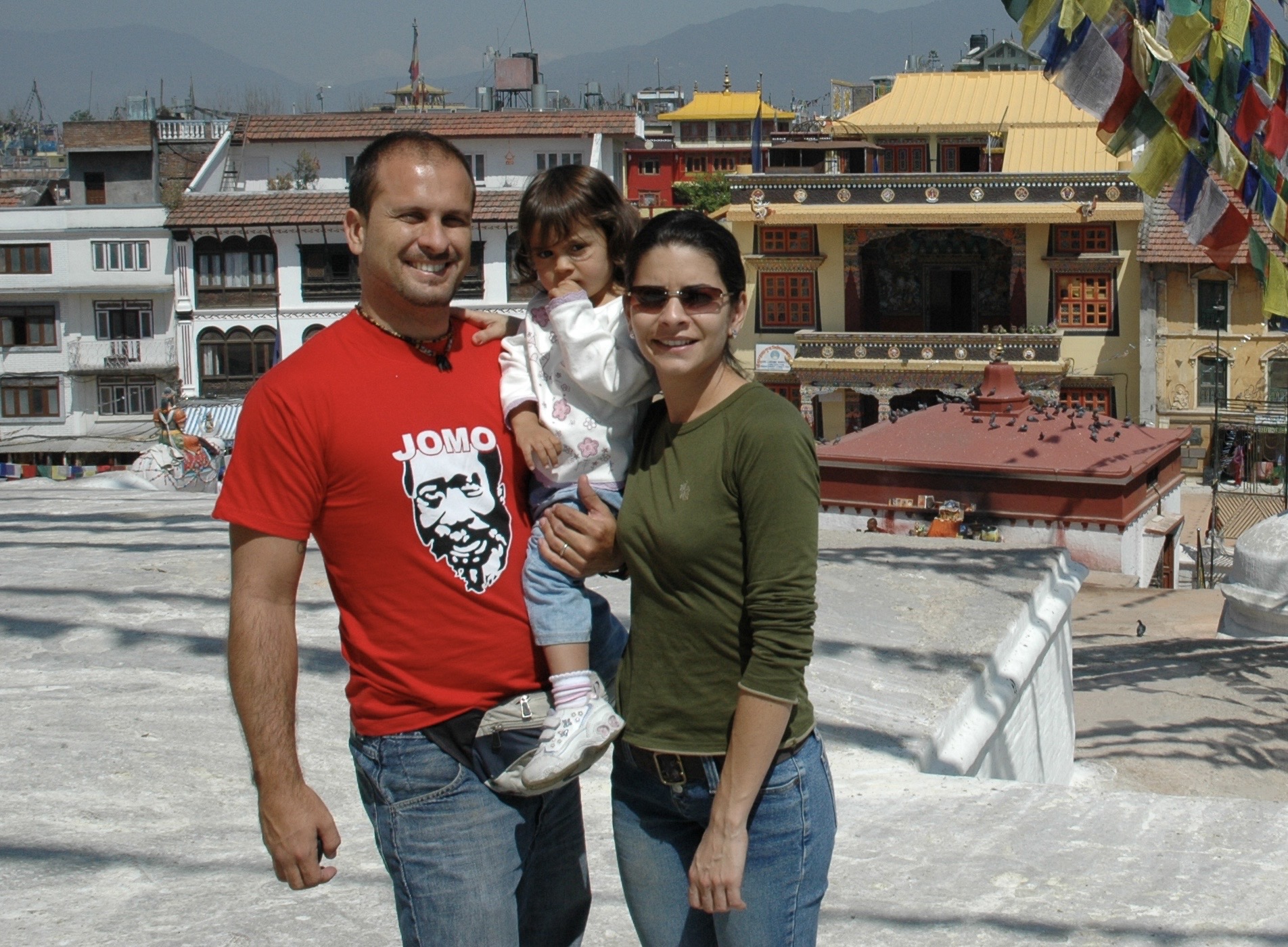 Family portrait on a Kathmandu rooftop with prayer flags