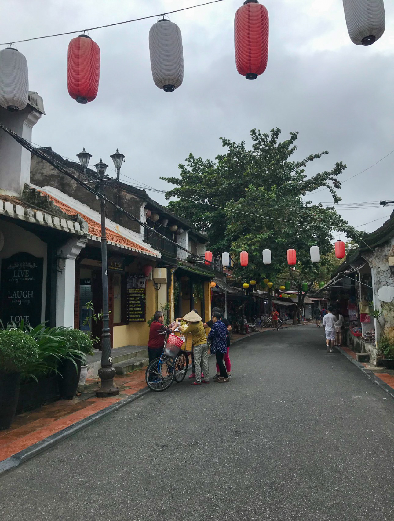 Red and white lanterns hanging over a Hội An street