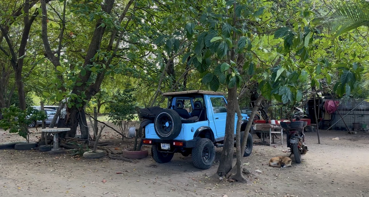 Blue jeep under shade trees in Costa Rica